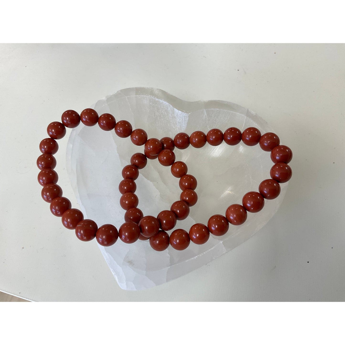 Red jasper bracelet side view, deep brick-red polished stone warrior crystal bead