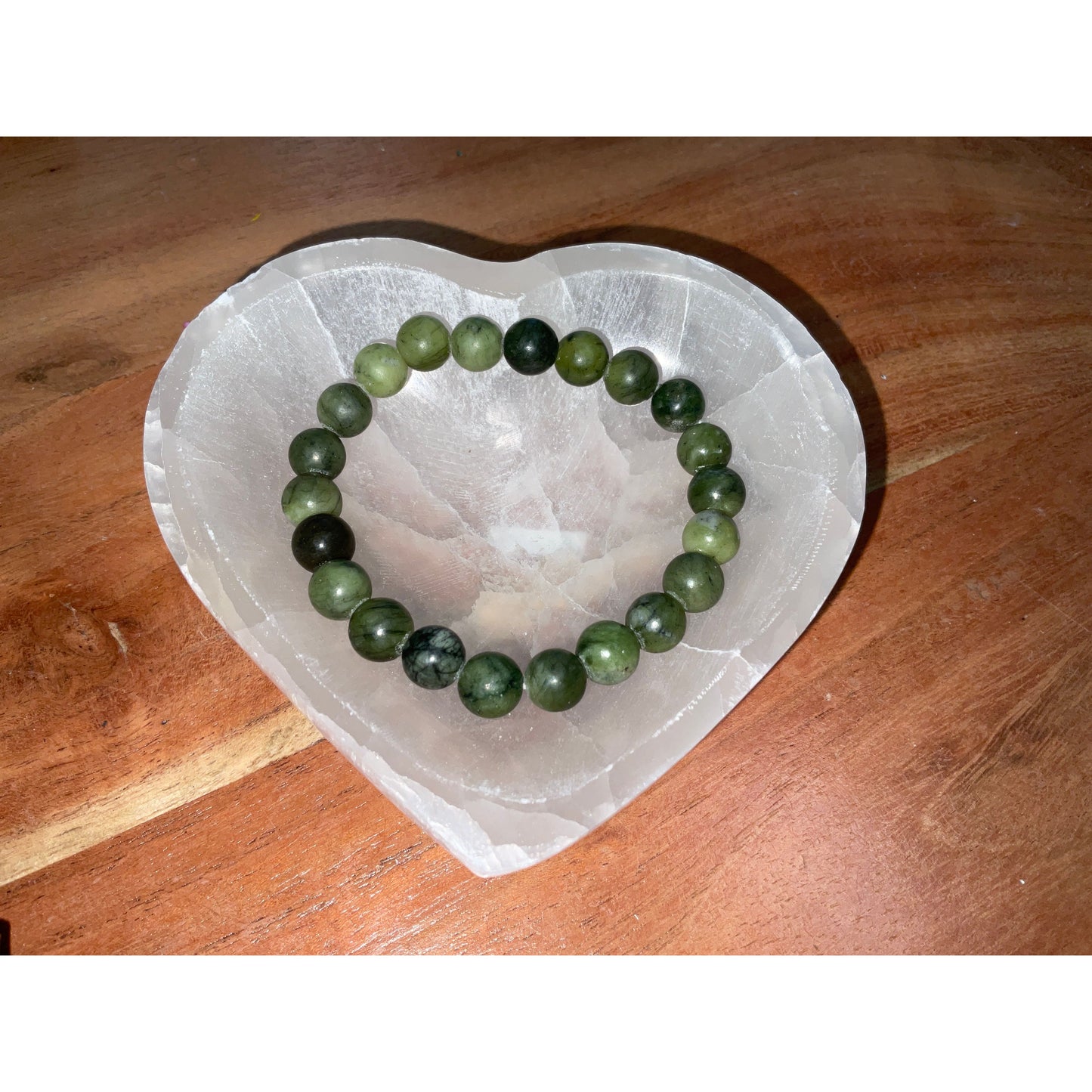 Serpentine jade bracelet side view, natural green polished stone bead detail