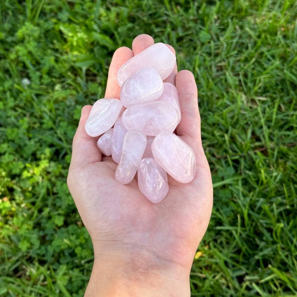 Rose quartz tumbled stone side view, smooth polished pink crystal